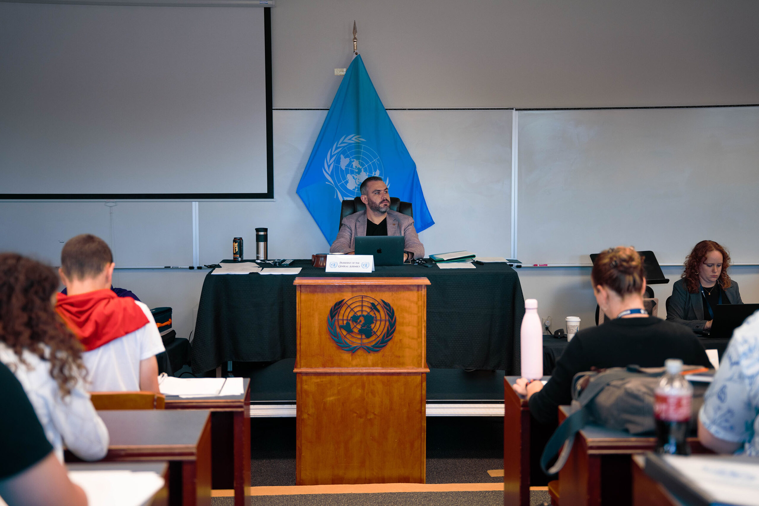 Speaker at UN podium with blue flag